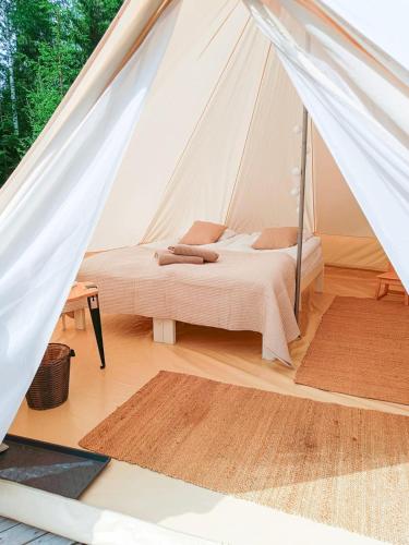 a bedroom with a bed in a tent at Venejoen Piilo - Sammal in Joensuu