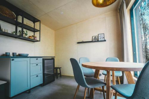a dining room with a table and blue chairs at Venejoen Piilo - Sammal in Joensuu