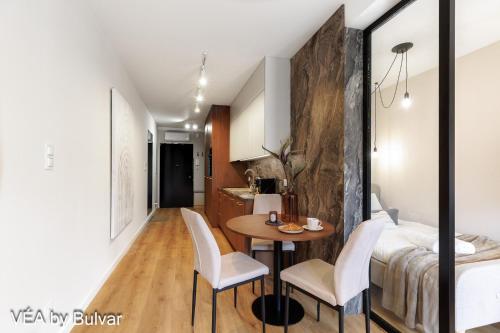 a room with a table and chairs and a bed at VÉA by Bulvar in Kielce
