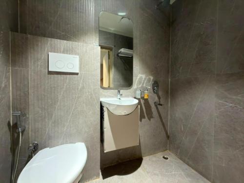 ein Badezimmer mit Waschbecken, Toilette und Spiegel in der Unterkunft Hotel Miralite in Tinsukia
