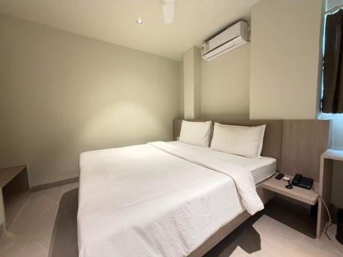 ein Schlafzimmer mit einem großen Bett mit weißer Bettwäsche in der Unterkunft Hotel Miralite in Tinsukia