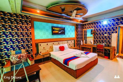 a bedroom with a bed and a desk in a room at Hotel Oasis International in Cox's Bazar