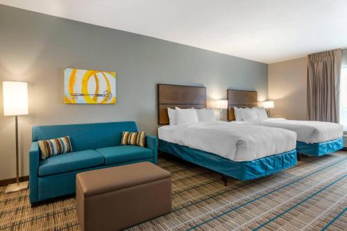 a hotel room with two beds and a couch at MainStay Suites Carlsbad South in Carlsbad