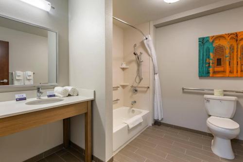a bathroom with a sink and a toilet and a bath tub at MainStay Suites Carlsbad South in Carlsbad