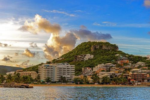 a resort on a hill next to a body of water at The Atrium Beach Resort and Spa Sint Maarten, Ascend Hotel Collection in Simpson Bay