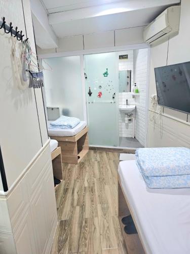a room with a bathroom with a shower and a sink at K & B Hostel in Hong Kong