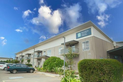 a building with cars parked in a parking lot at MainStay Suites Whyalla in Whyalla