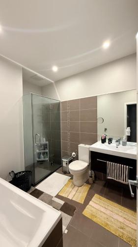 a bathroom with a toilet and a shower and a sink at Million Dollar View in Wellington