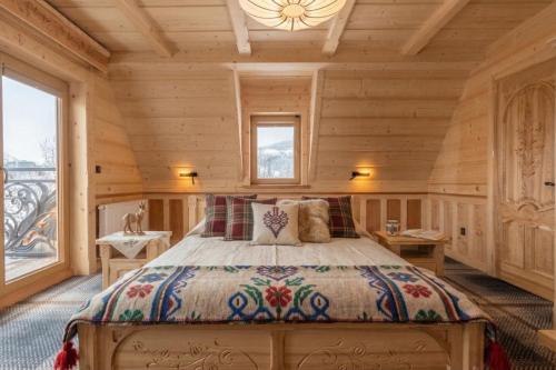 a bedroom with a bed in a wooden room at WHY NOT Myśliwska Exclusive Residence z basenem in Kościelisko
