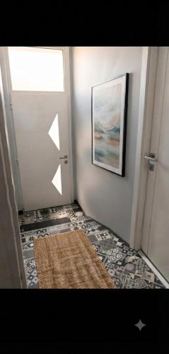 a hallway with a door with a rug and a picture at Notre bout du monde t1bis brest centre terrasse in Brest