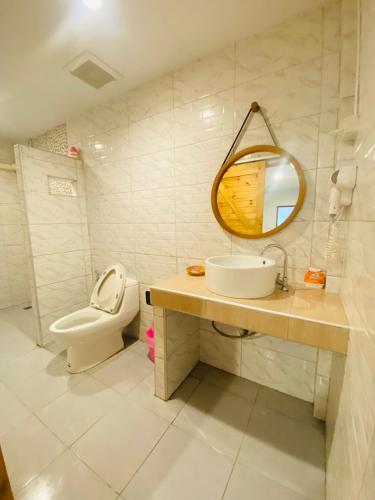 a bathroom with a sink and a toilet and a mirror at ลุงชีพบ้านพัก เกาะล้านLoongcheeb House in Ko Larn