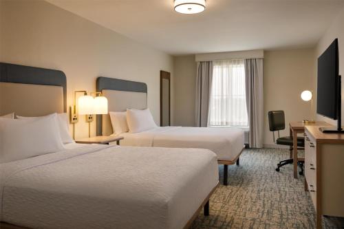 a hotel room with two beds and a television at Homewood Suites by Hilton Macon-North in Wesleyan Hills