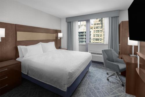 a bedroom with a bed and a desk and a chair at Hampton Inn Manhattan Grand Central in New York