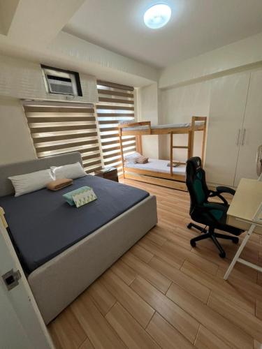 a bedroom with a bed and a desk and a chair at JFam Suites, C1-5L 1BR , Up To 7 Pax in Biñan