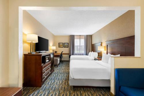 a hotel room with two beds and a flat screen tv at Comfort Inn & Suites Branson Meadows in Branson