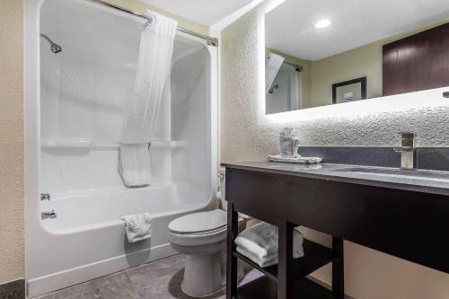 a bathroom with a toilet and a sink and a mirror at Quality Inn & Suites Salisbury South in Salisbury