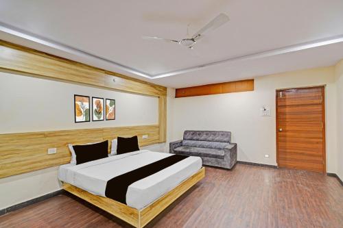 a bedroom with a bed and a chair at Collection O ECIL Industrial Estate Formerly Hotel Cube in Maula Ali