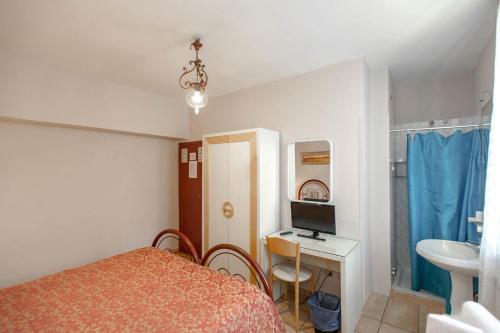 a bedroom with a bed and a desk with a computer at Hotel Masaccio in Florence