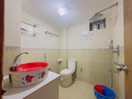 a bathroom with a red sink and a toilet at Impulse Ocean View in Cox's Bazar