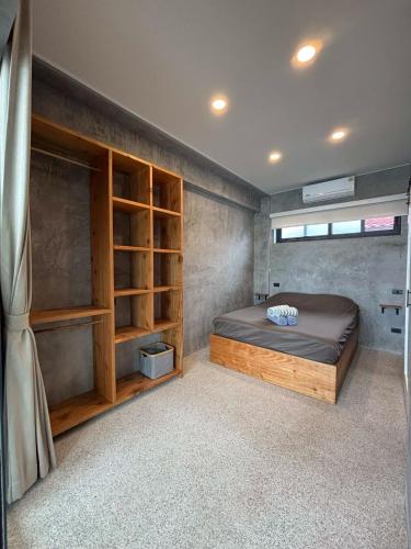 a bedroom with a bed and shelves in it at Big leaf villa cozy in Bangrak Beach