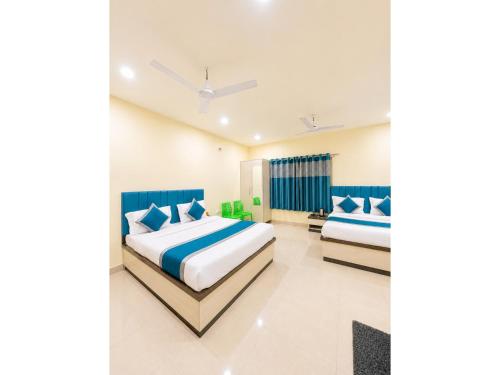 two beds in a bedroom with blue and white at HOTEL MEDHYA GRAND Near Goḏawalia Chauraha - 200 Meter From Baba Vishwanath Temple & Ganga Arti Ghat ! Wi-Fi #Lift #Hygiene & Spacious Room - BEST HOTEL IN VARANASI in Varanasi