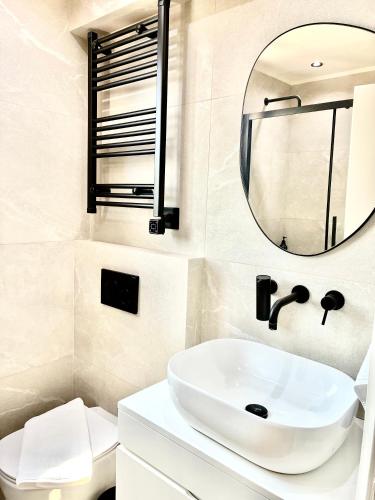 a bathroom with a white sink and a mirror at CasaSmaragdi in Perdika
