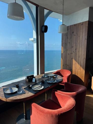 a table and chairs in a room with a large window at Skyline Privilege in Marriott in Batumi