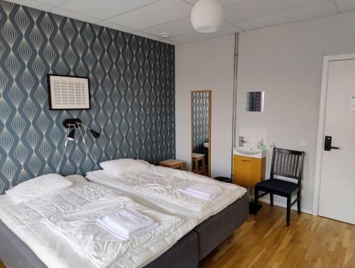 a bedroom with a bed and a chair at Avenyn Hostel, former Le Mat in Gothenburg