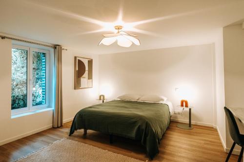 a bedroom with a bed and a ceiling fan at La Parenthèse Maisonneuve in Troyes