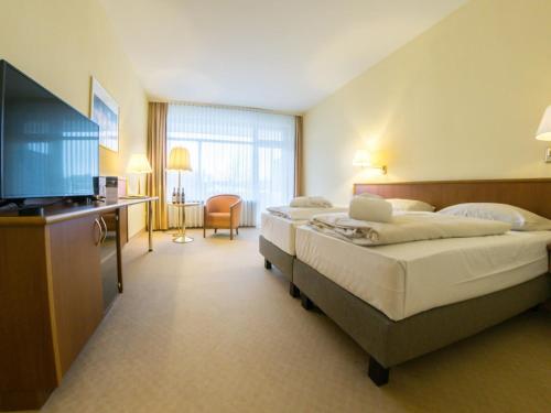 Postel nebo postele na pokoji v ubytování Spa & Wellnesshotel Bad Alexandersbad - Fichtelgebirge by Belvilla