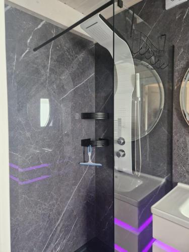 a bathroom with a glass shower with a sink and a toilet at San Escobar Dziwnówek in Dziwnówek