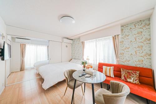 a bedroom with a bed and a table and a couch at Maple Hotel Tokyo in Tokyo