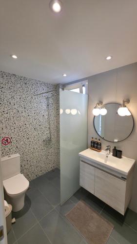 a bathroom with a toilet and a sink and a mirror at Bright & Bloom Luxury Studios in Hanioti