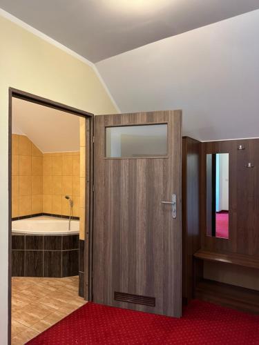 a bathroom with a door leading to a tub at Viktorjan in Raszowa