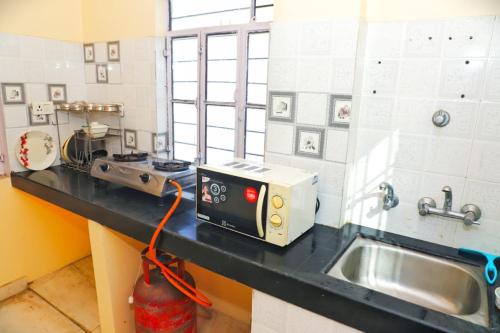 a kitchen with a sink and a microwave on a counter at Hotel Relax in Jaipur