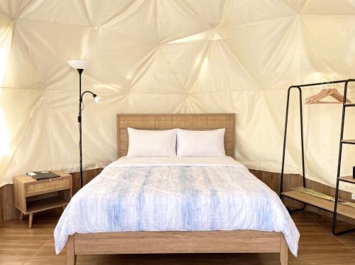 a bedroom with a bed in a tent at Zatura Dome Glamping in Panjadakan