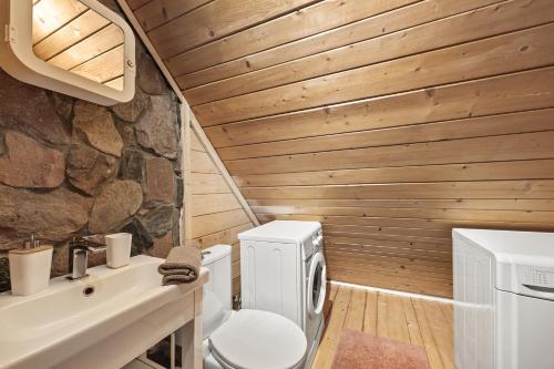 a bathroom with a toilet and a stone wall at Przystanek Zielnik in Łosie