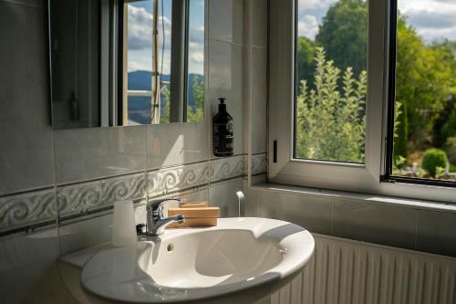 a white sink in a bathroom with a window at A Casa Das Chocas in San Román