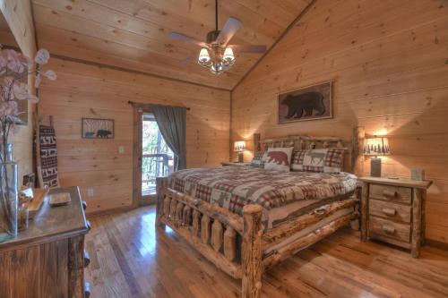 a bedroom with a bed in a log cabin at Squirrels Hideaway Fire Pit MTN Views in Copperhill