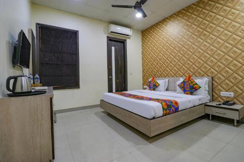 ein Schlafzimmer mit einem großen Bett und einem Fernseher in der Unterkunft Hotel De Agya in Ludhiana