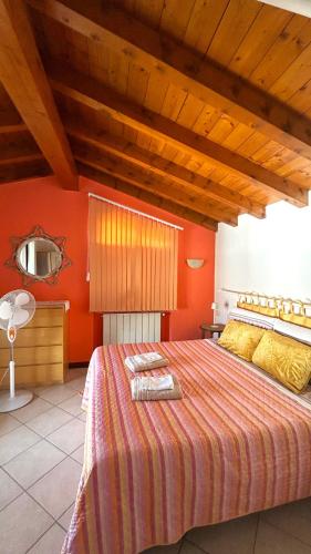ein Schlafzimmer mit einem großen Bett und orangefarbenen Wänden in der Unterkunft L'Oasi Intelvese in Pellio Superiore
