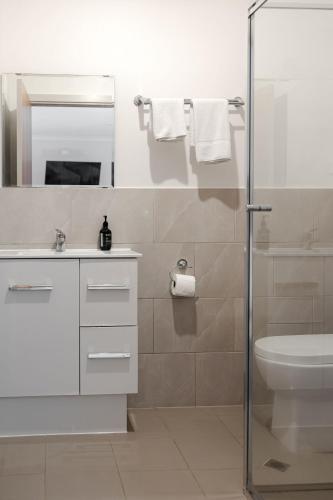 a bathroom with a sink and a toilet and a shower at Bayview Cabins Kangaroo Island in American River