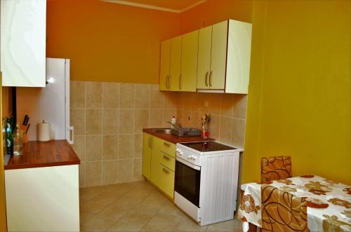 een keuken met gele en witte kasten en een wastafel bij Apartments Md Lux 2 in Sutomore