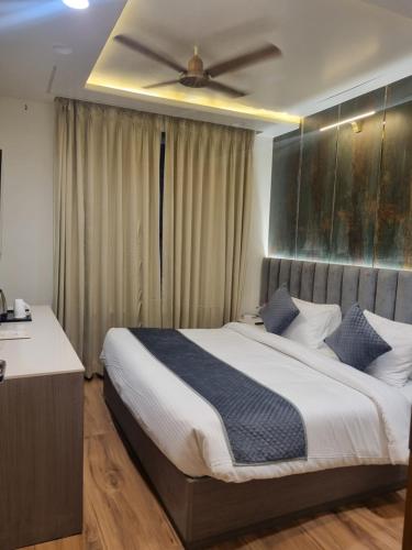 a bedroom with a large bed with a ceiling fan at Platinum Arc in Jaipur