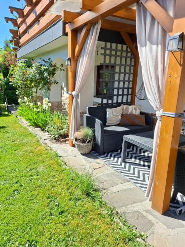 a patio with a couch under a wooden pergola at U Hanki in Biały Dunajec