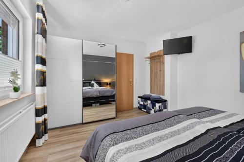 a bedroom with a bed and a large mirror at Suite Stadtgrün in Papenburg