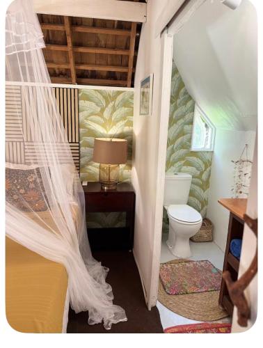 a small bathroom with a bed and a toilet at Atunumai in Temae