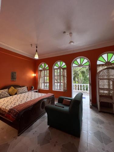 a bedroom with orange walls and a bed and a couch at Villa Rivercat in Mandrem