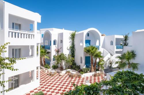 a view of a white building with palm trees at Kamari Beach Hotel in Kamari