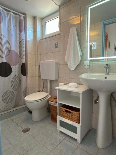 a bathroom with a toilet and a sink at Thea in Myrtos